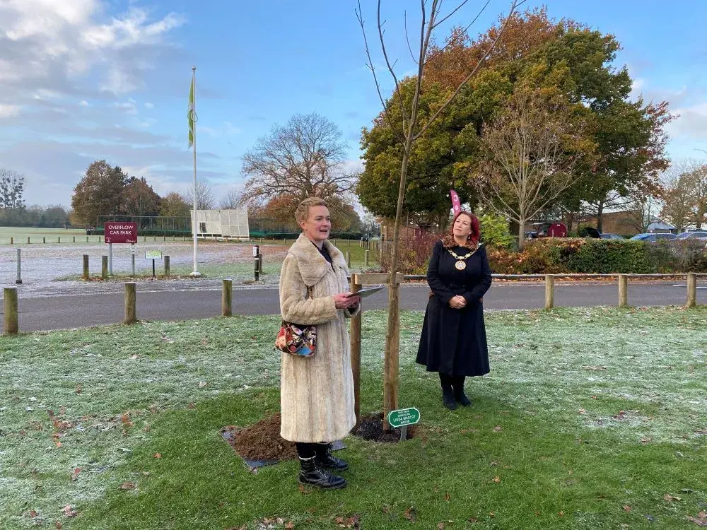 Cllr Moore giving speech next to the Mayor, Cllr Mascot in front of tree