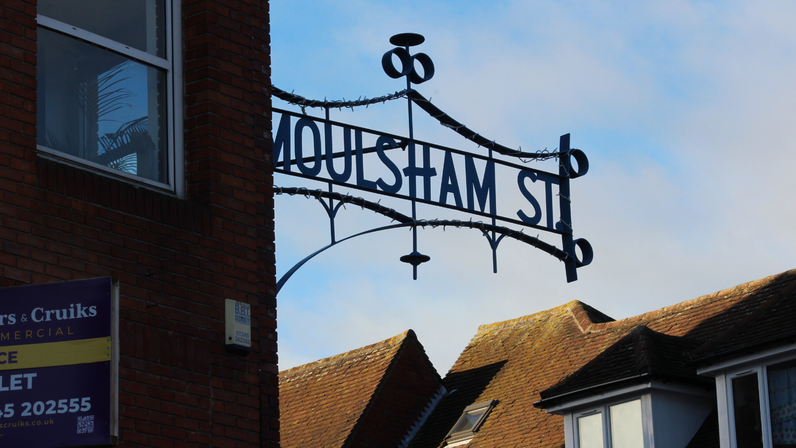An Iron Sign Hanging From A Brick Building Reads 'Moulsham Street'