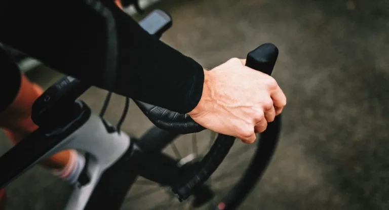 A Cyclists Hand On Their Bike's Handle