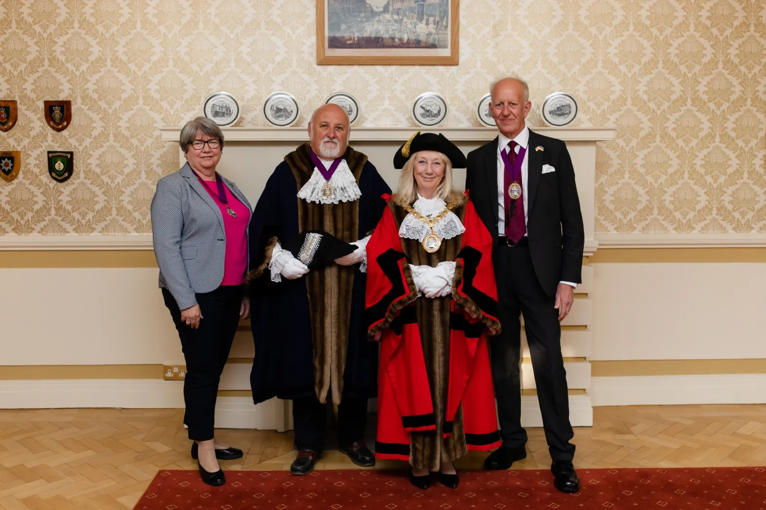 Mayor Dobson And Deputy Massey wearing official robes and chains, standing with their partners