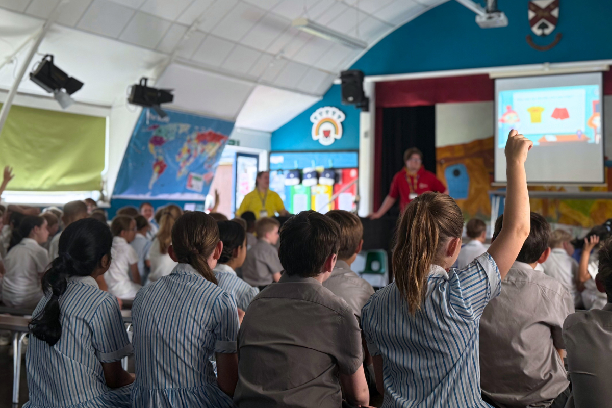 A child raises her hand during Westlands primary school's water safety assembly.png
