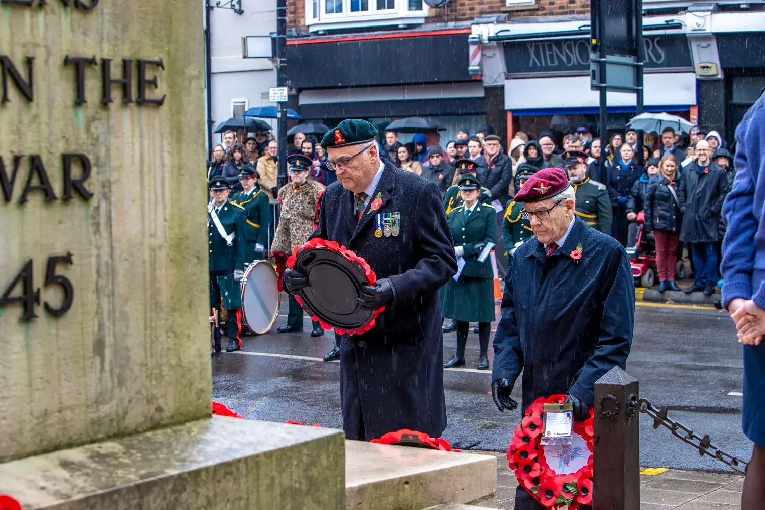 Decorated veterans laying down poppy wreath at war memorial