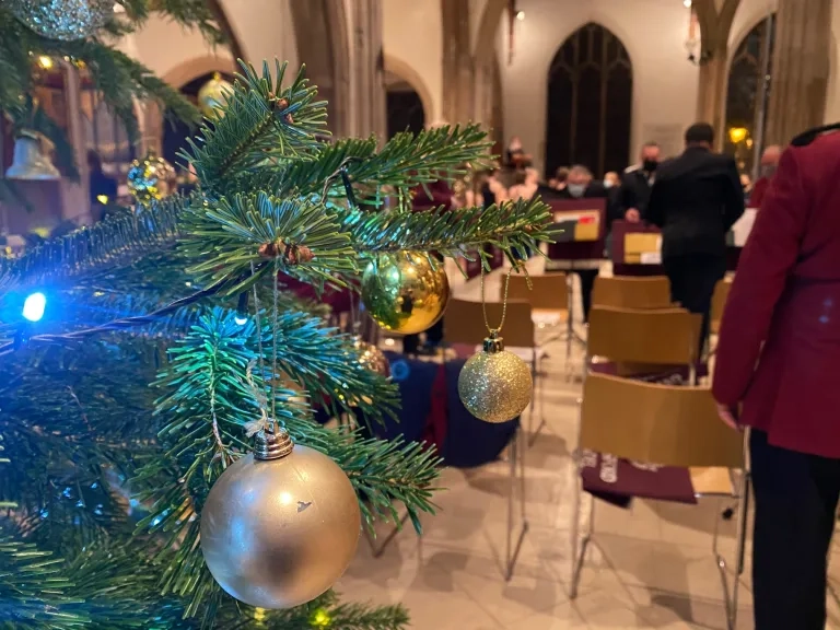 Christmas tree with carol singers in the background