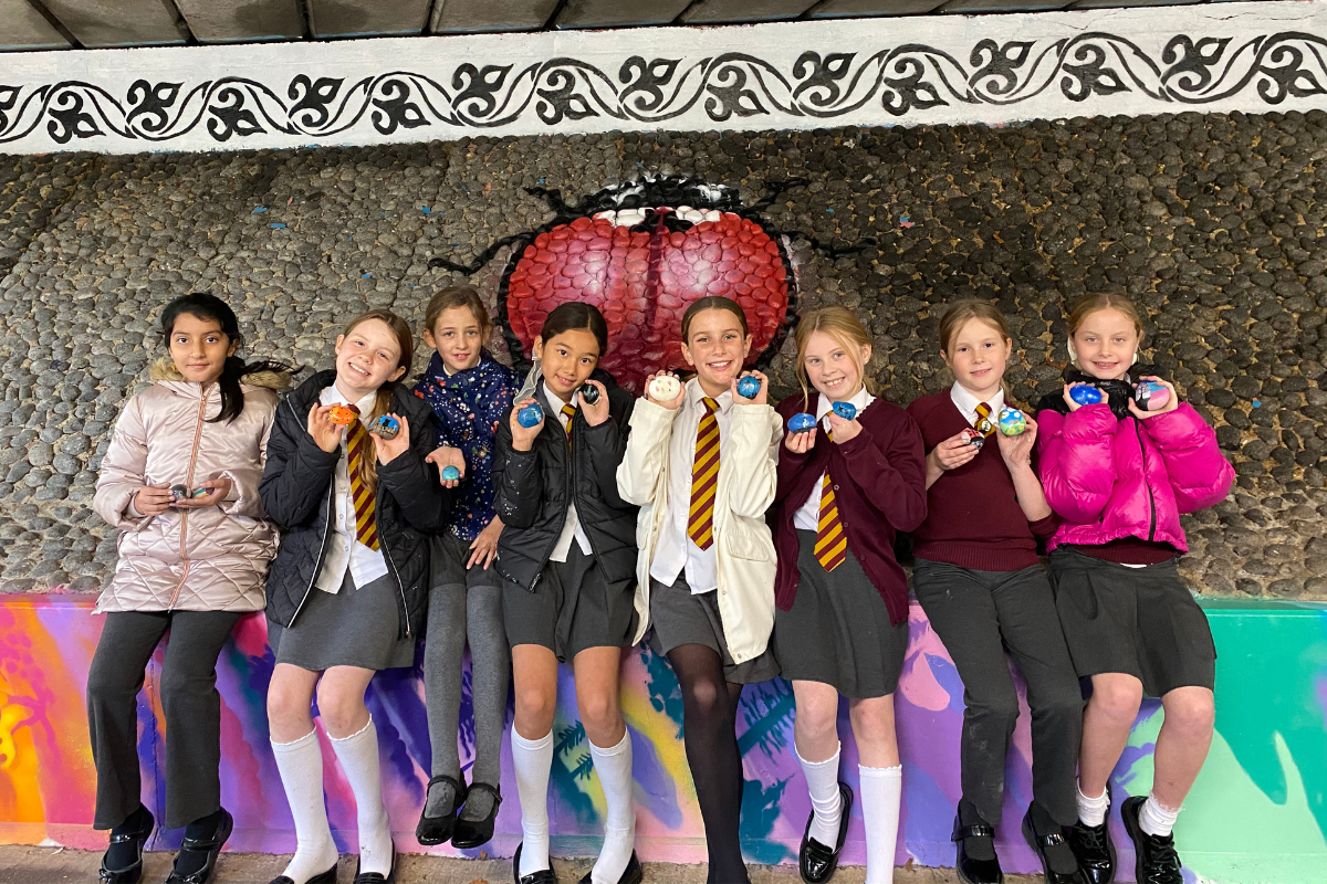 Primary School Students Smile At The Camera While Watching Artists At Work In Central Park