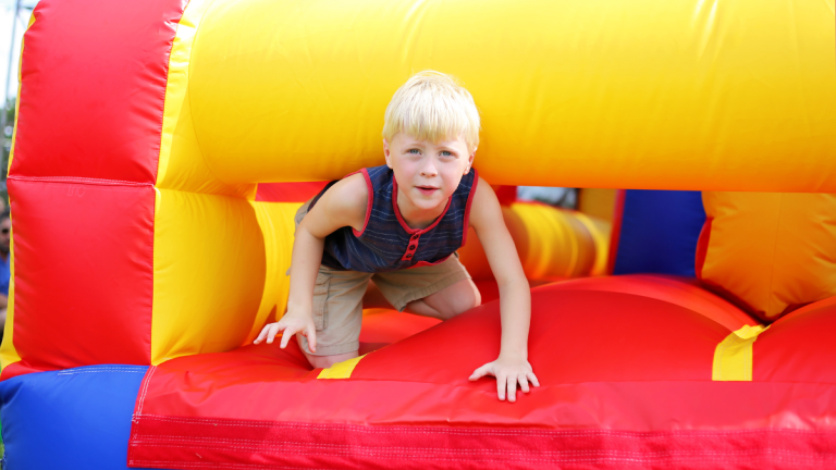 Boy Playing On Bouncy Castle