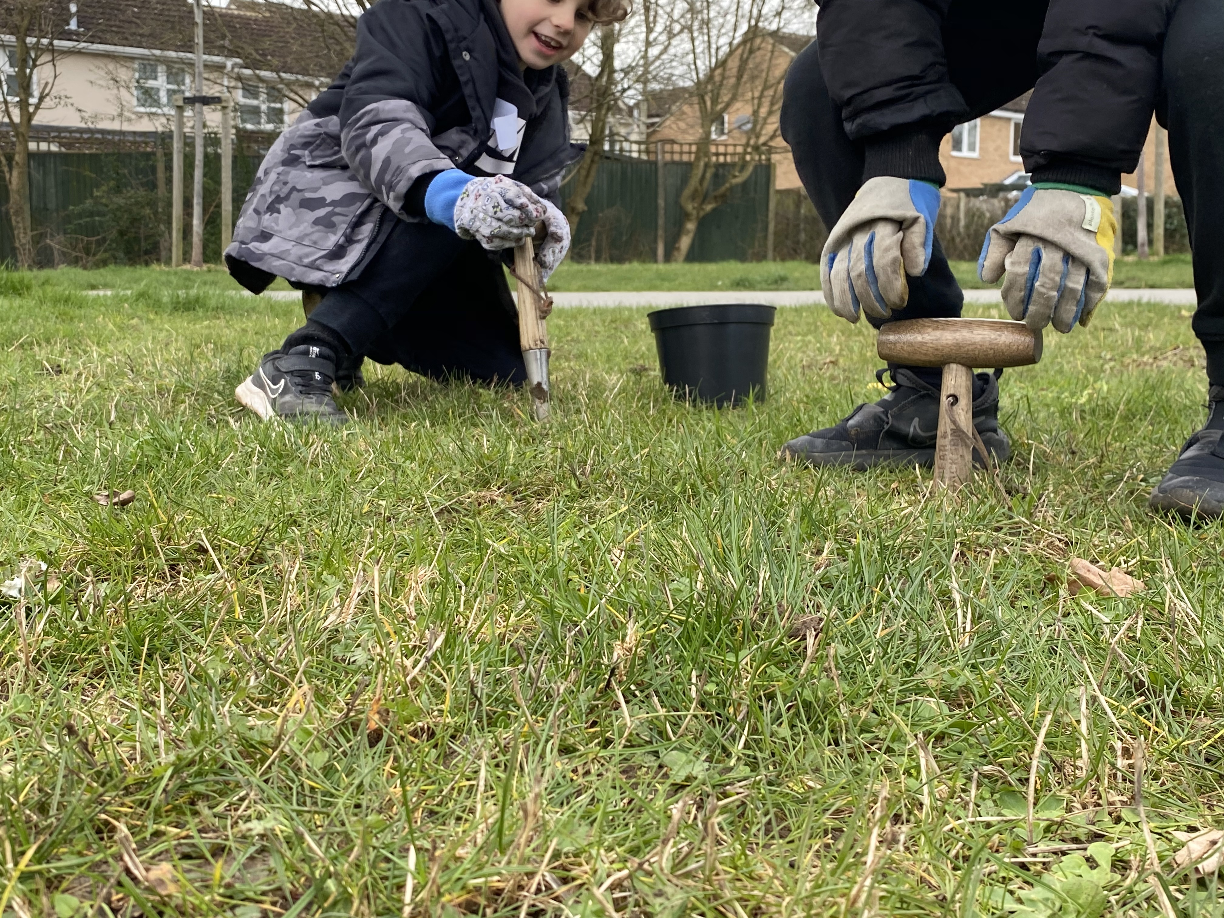 Two students planting wildflowers