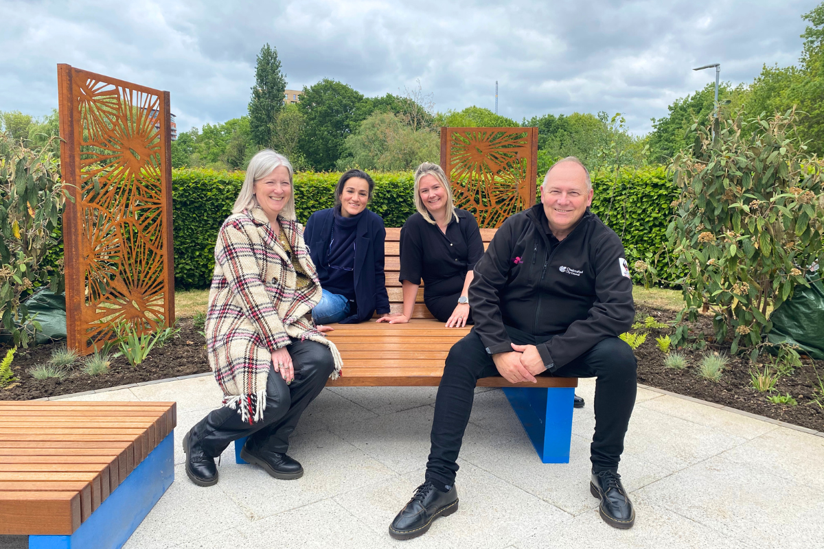 Imogen Clark, Julia King, Kaylie Charlery and Spencer Clark sit on one of the benches at the Our Place opening event.png