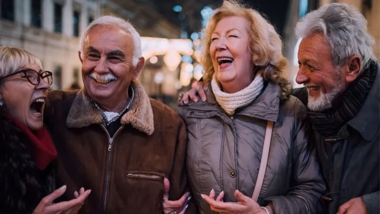 Group Of Older People Laughing And Talking Together Outdoors