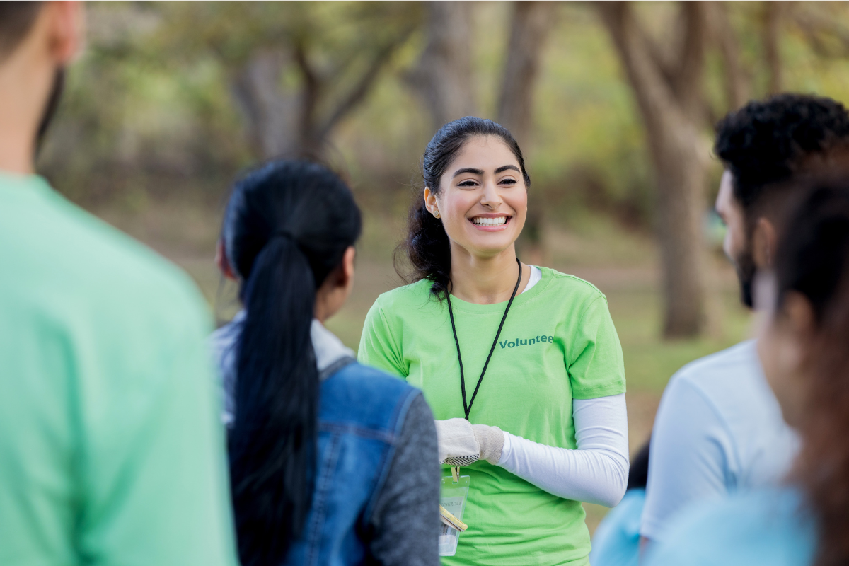 A volunteer smiling at a group of teenagers.png