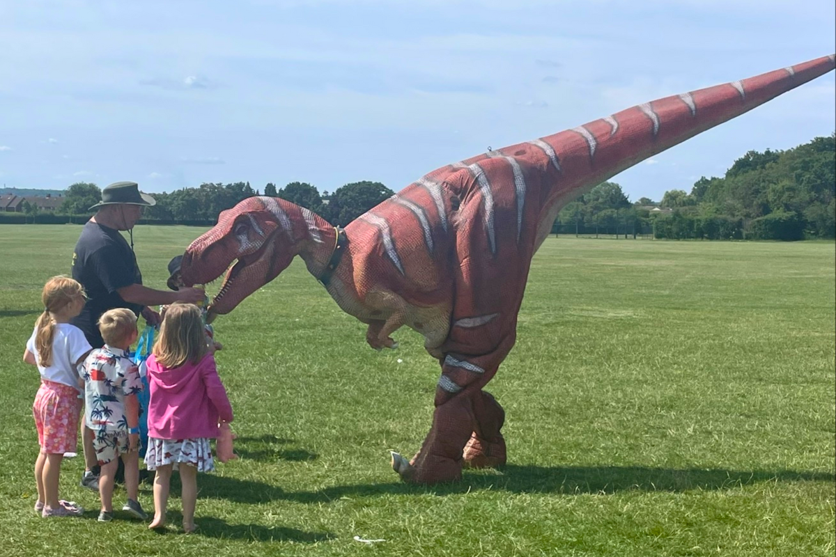 Children Meeting A Walking Dinosaur At Picnic In The Park 2023