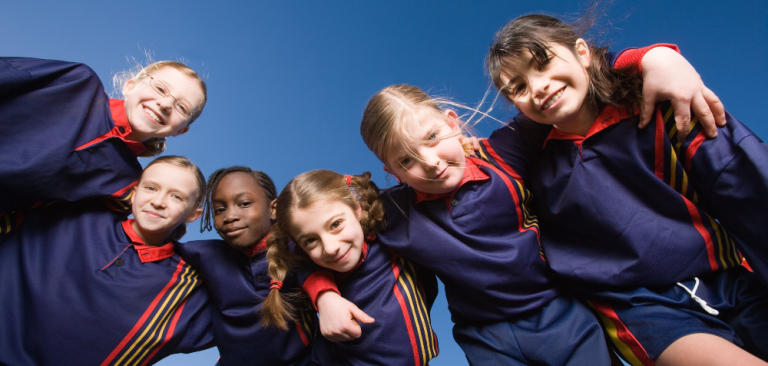 6 children in uniform smiling at camera