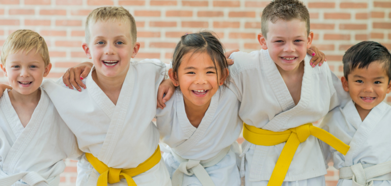 5 children smiling dressed in karate gear
