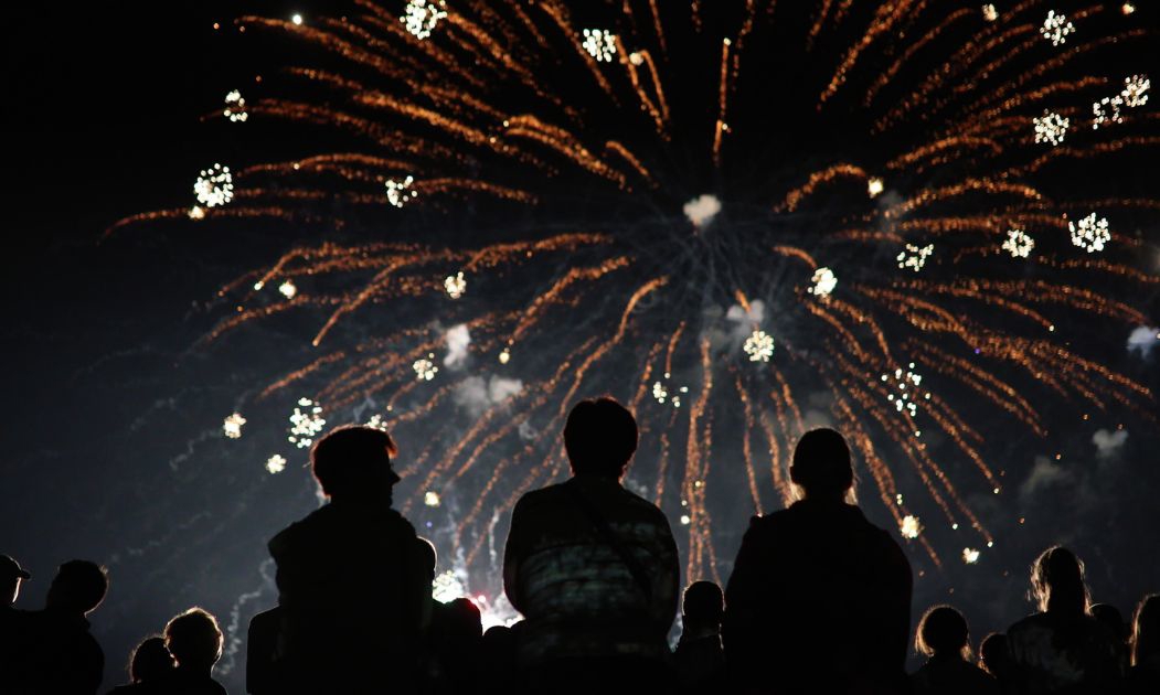 Back of heads watching fireworks in the sky