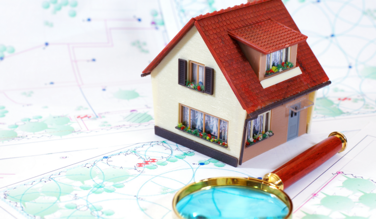 Model House On Map With Magnifying Glass