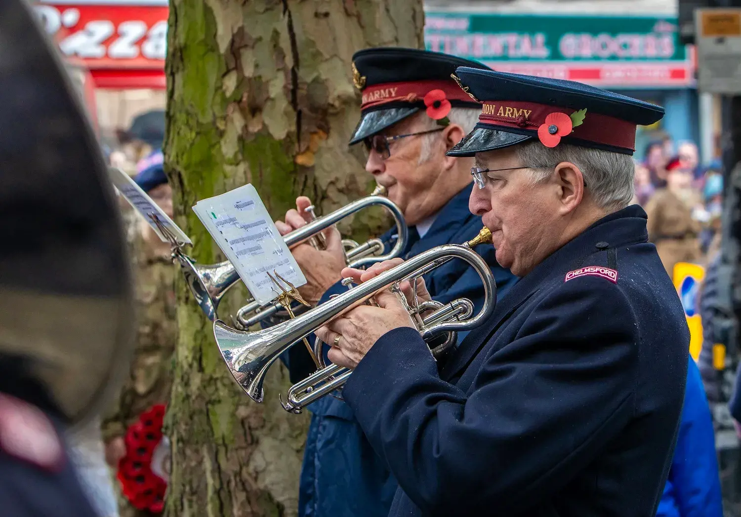Two men playing trumpets at war memorial