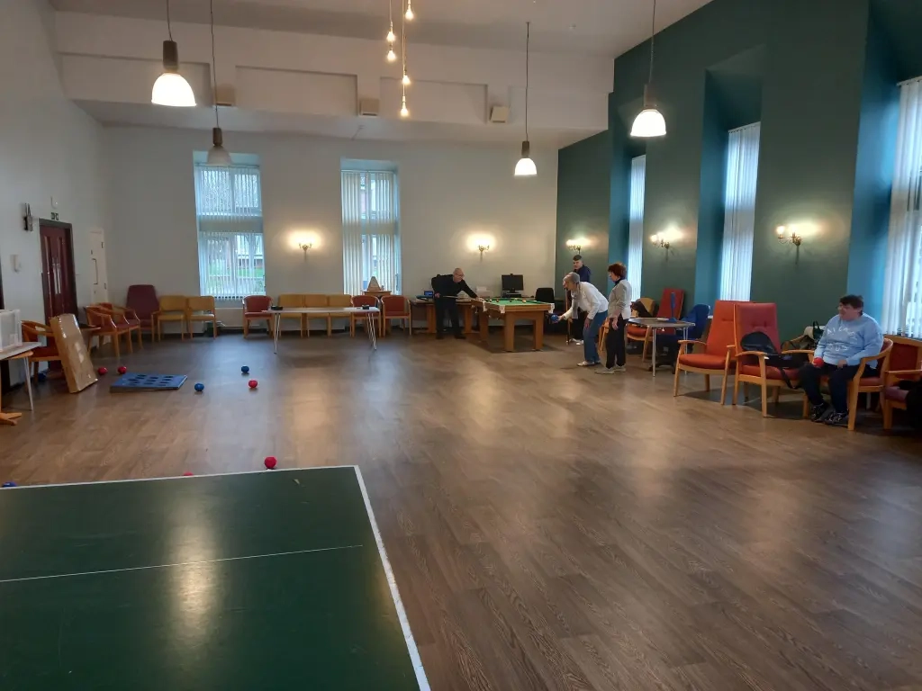 CHP Residents Playing Bowls In Hall With Wooden Floor