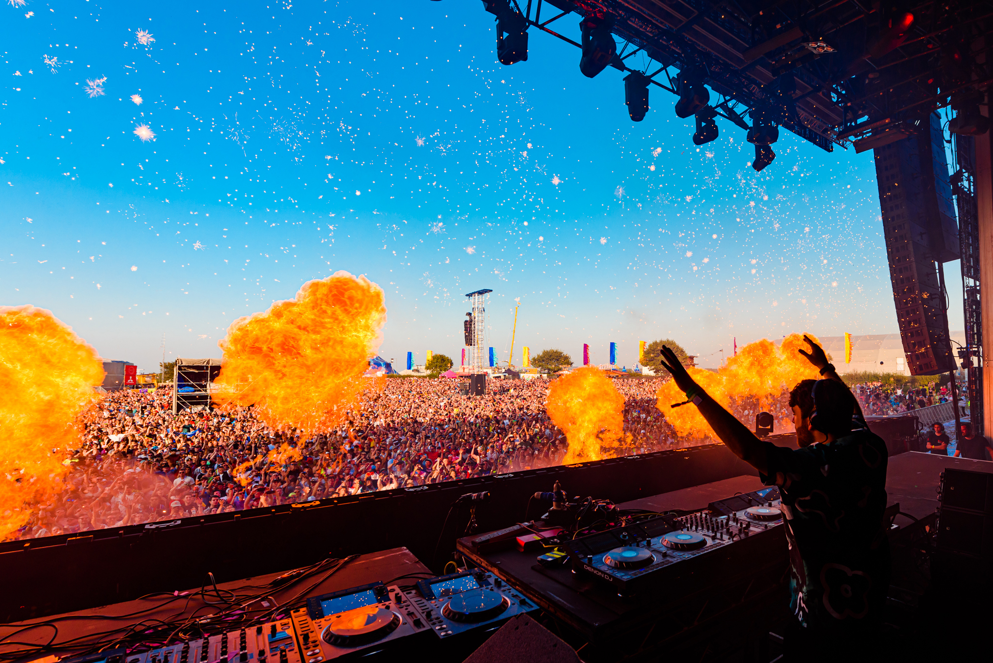 A Dj Looks Out At A Crowd Of Festivalgoers With Flame Effects In The Foreground. Copyright Anthony Mooney