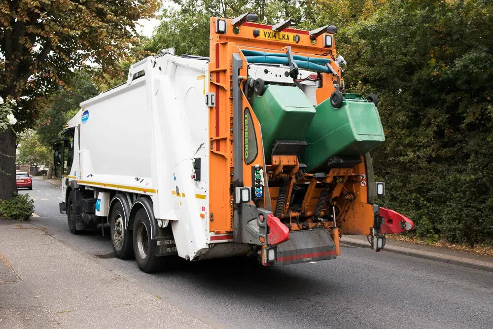 White bin lorry with green bins