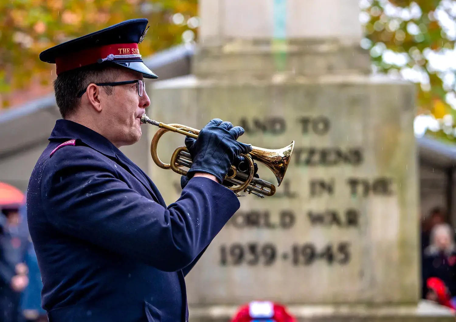 Trumpet being played in front of war memorial