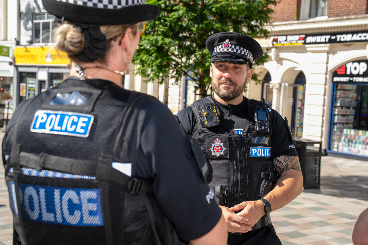 Chief Inspector Aaron Homatopoulos speaks to a colleague in Chelmsford High Street.png