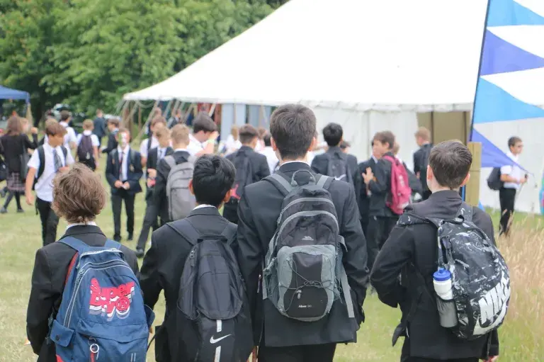 Students Walk Towards A Tent