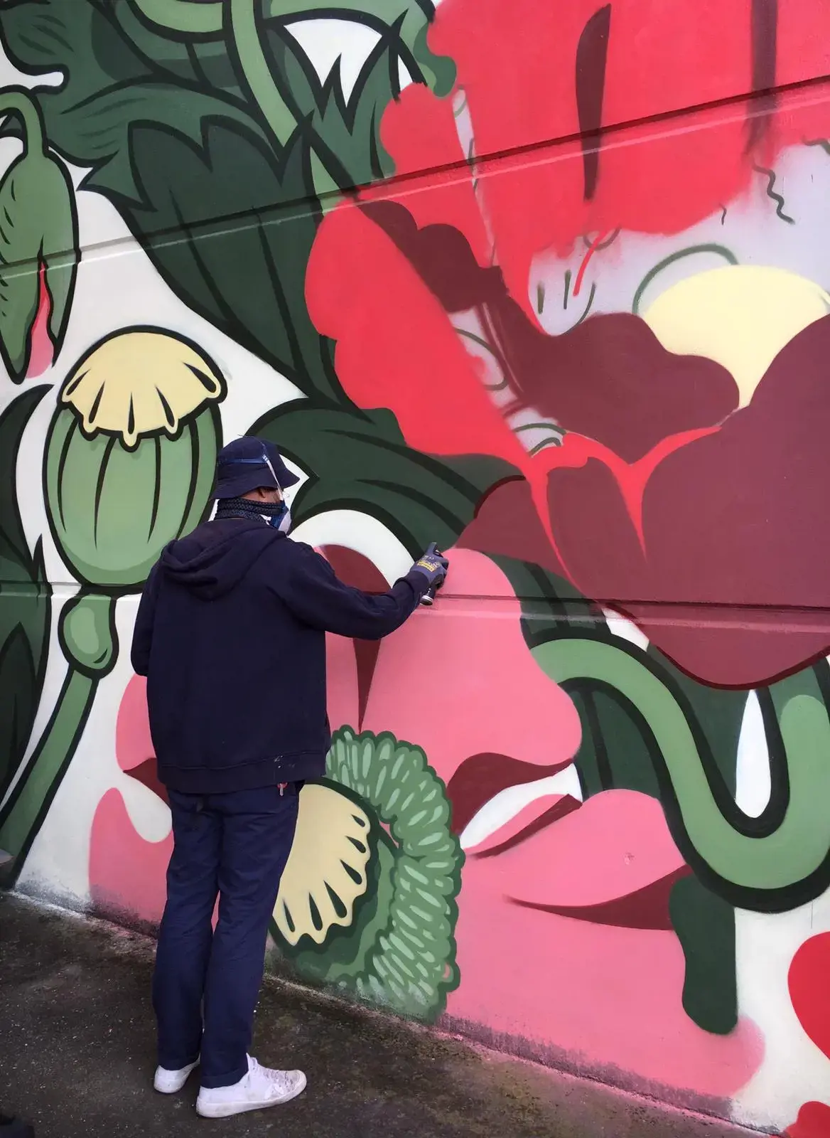 An artist working on a mural as part of the Concrete Canvas project