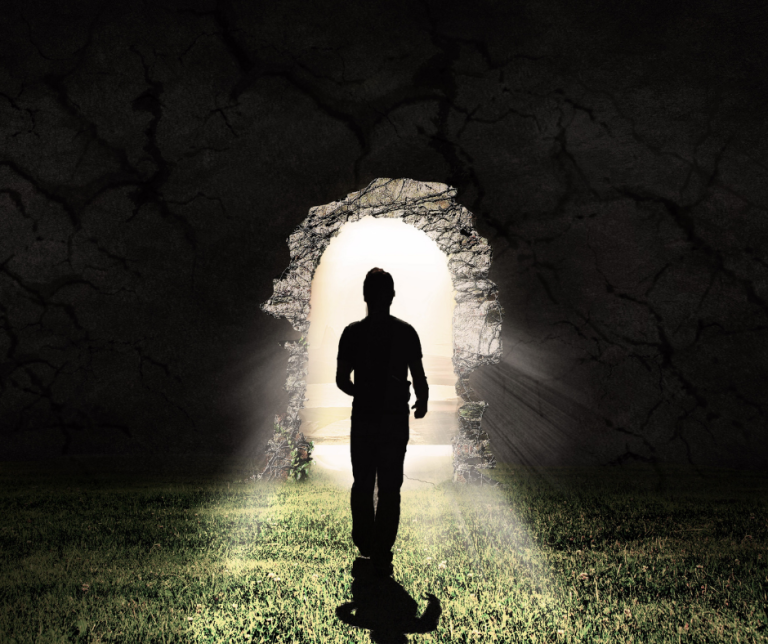 Person walking towards light and the end of a tunnel